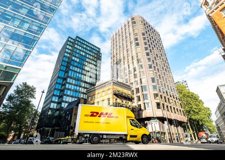 London, November 2022: Anzahl der hohen Londoner Bürogebäude mit DHL-Lieferwagen Stockfoto