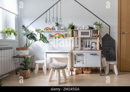 Weißer Kinderküche-Raum mit frühem Entwicklungsspielraum und Montessori-Holzmaterialien Stockfoto