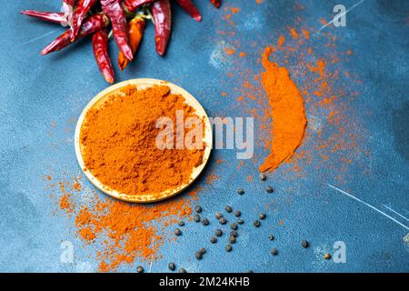 Roter Pfeffer in verschiedenen Stufen. Getrockneter und pulverisierter roter Pfeffer auf dunklem Hintergrund. Stockfoto