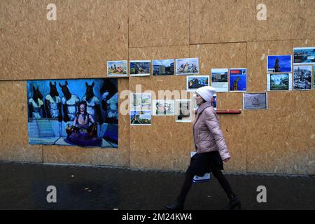 Odessa, Ukraine. 06.. Dezember 2022. Die Frau sieht man, wie sie an Gemälden von Denis Nedoluzhenko in der Deribasovskaja Straße vorbeigeht. Die Ukrainer versuchen mit allen Mitteln, das russische Kolonialerbe loszuwerden. Eine davon war eine Ausstellung von Werken von Denis Nedoluzhenko, die Fragen nach dem Ort der Denkmäler des Erbes des russischen Reiches aufwirft. Denis Nedolkzhenko ist ein Künstler aus Odessa, der im Stil der "neuen Materialität" arbeitet - eine Reflexion der Zeit ohne Romantisierung und Verzierung. (Foto: Viacheslav Onyshchenko/SOPA im/Sipa USA) Guthaben: SIPA USA/Alamy Live News Stockfoto