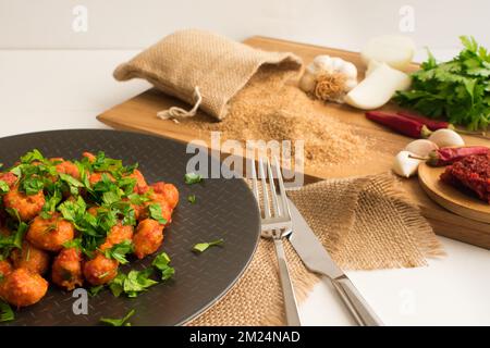 Traditionelles türkisches Essen „Fellah Kofte“, bulgurige Fleischbällchen mit Tomatenpaste und Knoblauch. Stockfoto