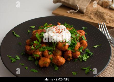 Traditionelles türkisches Essen „Fellah Kofte“, bulgurige Fleischbällchen mit Tomatenpaste und Knoblauch. Stockfoto