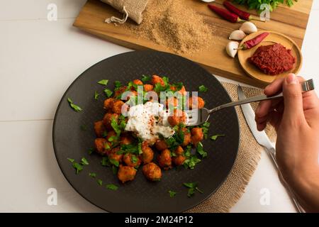 Traditionelles türkisches Essen „Fellah Kofte“, bulgurige Fleischbällchen mit Tomatenpaste und Knoblauch. Stockfoto