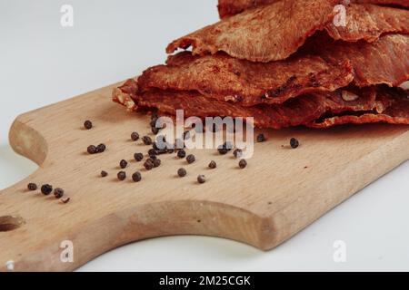 Einige handgefertigte Pappkartons mit dehydrierten Hundefreuden, die höchste ist geöffnet, voller trockenem Fleisch knusprigen Geschmacks von Rind und Huhn. Hausgemachtes Haustier Stockfoto