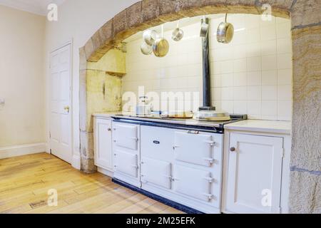 Landhausküche mit Aga-Ofen und hängenden Pfannen. Stockfoto