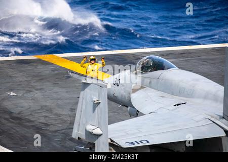 San Diego, Usa. 10. Dezember 2022. EIN US-AMERIKANISCHER Der Navy Deck Handler leitet ein F/A-18F Super Hornet Kampfflugzeug, mit den Kestrels des Strike Fighter Squadron 137 zum Parkplatz auf dem Cockpit des Nimitz-Klasse Flugzeugträgers USS Nimitz auf dem Pazifik, 10. Dezember 2022 nahe Kalifornien, USA. Kredit: MC1 Nathan Laird/U.S. Navy/Alamy Live News Stockfoto