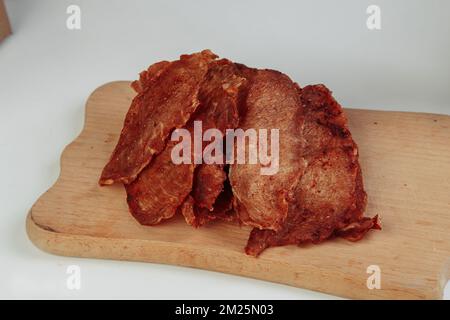 Einige handgefertigte Pappkartons mit dehydrierten Hundefreuden, die höchste ist geöffnet, voller trockenem Fleisch knusprigen Geschmacks von Rind und Huhn. Hausgemachtes Haustier Stockfoto