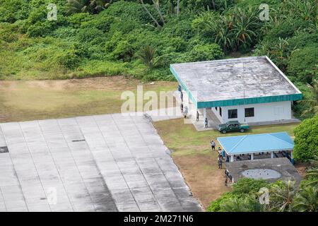 Ulithi-Atoll, Föderierte Staaten von Mikronesien. 04. Dezember 2022. Inselbewohner aus Ulithi winken in die USA Air Force C-130J Hercules Flugzeug, das während Operation Christmas Drop 2022, 4. Dezember 2022 in Ulithi Atoll, Carolina Islands, FSM, ein Frachtpaket abwirft. Operation Christmas Drop ist die älteste humanitäre und Katastrophenhilfemission, die 71.000 Pfund Nahrungsmittel, Geschenke und Vorräte zur Unterstützung abgelegener Inselgemeinden im Südpazifik liefert. Kredit: Yasuo Osakabe/US Airforce Photo/Alamy Live News Stockfoto