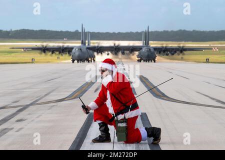 Yigo, Usa. 10. Dezember 2022. USA Oberstleutnant Jeffrey Furnary, in Santa-Kostüm gekleidet, funkt C-130-Frachtpiloten an, während sie sich für Operation Christmas Drop 2022 auf der Landebahn der Andersen Air Force Base, 10. Dezember 2022 in Yigo, Guam, vorbereiten. Sieben C-130-Flugzeuge aus den USA Air Force, Royal Australian Air Force, Japan Air Self-Defense Force, Republic of Korea Air Force und Royal New Zealand Air Force lieferten 71.000 Pfund Lebensmittel, Geschenke und Vorräte, um entlegenen Inselgemeinden im Südpazifik zu helfen. Kredit: Yasuo Osakabe/US Airforce Photo/Alamy Live N. Stockfoto