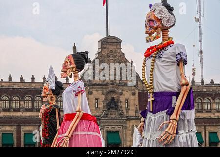 Mexiko-Stadt, Mexiko. 28. Oktober 2022. Während des Megaofrenda of Zocalo Festivals um die riesigen Skulpturen von Catrina, der Skelettbraut, versammeln sich Menschenmassen, um den Beginn des Feiertags des Todes am Plaza de la Constitucion am 28. Oktober 2022 in Mexiko-Stadt, Mexiko, zu feiern. Stockfoto