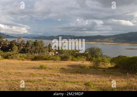 Wunderschöne Aufnahmen einer Naturlandschaft des kolumbianischen Sees mit andenbergen und weißen Wolken im Hintergrund in der goldenen Stunde am Nachmittag Stockfoto