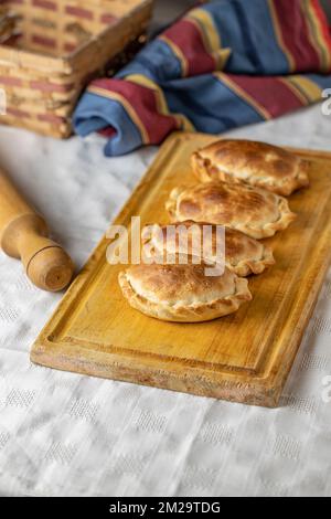 Traditional baked Argentinian empanadas on a board. Stock Photo