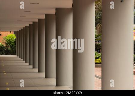 Graue Säulen eines Gebäudes in geometrischem Muster mit weichem Schatten. Architektur und geometrisches Konzept Stockfoto