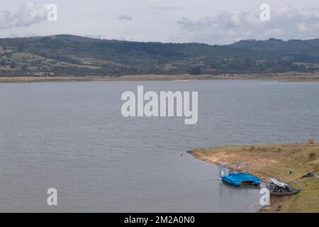 GUATAVITA, KOLUMBIEN - Tomine Lake am sonnigen Morgen mit Bergen und grauem Himmel Stockfoto