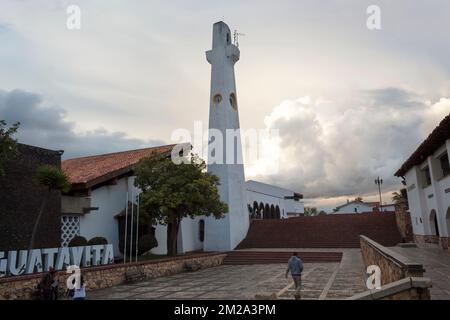 GUATAVITA, KOLUMBIEN - Hauptplatz der kolumbianischen Stadt mit dem Schriftzug „i love guatavita“, der Hauptkirche und dem Uhrenturm mit bewölktem Himmel am Abend Stockfoto