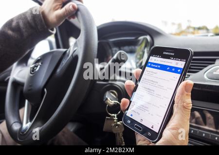 Unverantwortlicher Mann am Lenkrad, der Nachrichten auf Smartphone/Smartphone/Mobiltelefon während der Fahrt mit dem Auto auf der Straße überprüft | Homme derrière volant lisant Nachrichten auf Smartphone/téléphone mobile en roulant en voiture 17/11/2017 Stockfoto