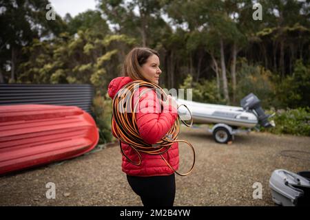 Wunderschöne Elektrikerin mit Verlängerungskabeln auf einer Baustelle in australien Stockfoto