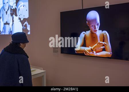 Elderly woman looking at television screen showing female android / humanoid robot at exposition about robotics and artificial intelligence / AI | Femme agée regarde androïde pendant exposition concernant la robotique et intelligence artificielle 26/11/2017 Stock Photo