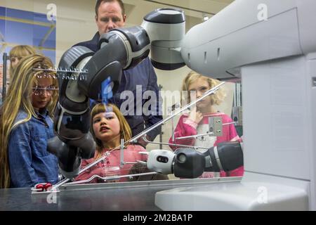 Neugierige Kinder schauen auf Demonstrationen mit industriellen Roboterarmen bei einer Ausstellung über Robotik und künstliche Intelligenz / KI | Enfants regardent démonstration d'un robot industriel Hängeausstellung betrifft la robotique et Intelligence artifizielle 26/11/2017 Stockfoto