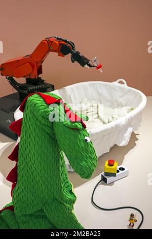 Roboter Baby Feeder, Abschaltschalter zum Deaktivieren von Roboter und Drachenkostüm, um Industrieroboter zugänglicher zu machen | Roboter Baby Feeder, Roboter industriel avec Biberon et Kostüm de Dragon 26/11/2017 Stockfoto