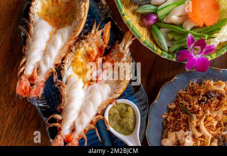 Grilled giant river prawn in a Thai luxury restaurant. Seafood in Thailand. Grilled giant river prawn served on a plate with Thai seafood sauce. Thai Stock Photo