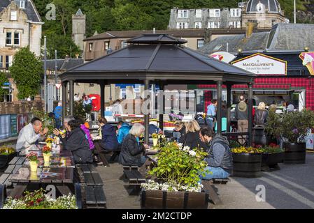 Touristen, die Meeresfrüchte bei Fish and Chips in der Stadt Oban, Argyll and Bute, Schottland, Großbritannien, essen | Touristes ManSergeant des Fruits de mer dans le Port de la Ville Oban, Argyll and Bute, Ecosse, Royaume-Uni 05/06/2017 Stockfoto