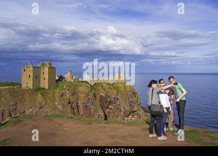 Touristen machen Selfies in Dunnottar Castle, Ruine mittelalterliche Festung in der Nähe von Stonehaven auf Klippen entlang der Nordseeküste, Aberdeenshire, Schottland, Großbritannien | Château de Dunnottar, forteresse médiévale en Ruine à Stonehaven, Aberdeenshire, Ecosse, Royaume-Uni 24/05/2017 Stockfoto