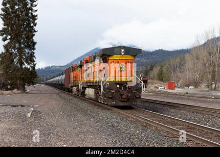 Die Tailing GE C44-9W Diesel-Schublokomotive eines BNSF Öltanker-Güterzugs, der die Gleise in Troy, Montana, entlangfährt. Stockfoto