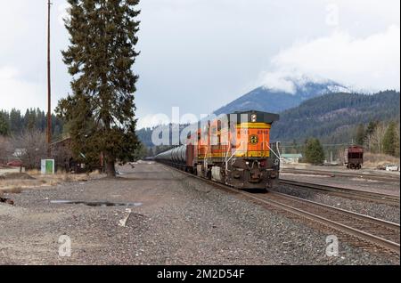 Troy, Montana, USA. 23. Februar 2021. Die Tailing GE C44-9W Diesel-Schublokomotive eines BNSF-Öltanker-Güterzuges, der die Gleise entlang fährt. Stockfoto