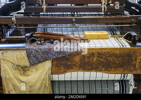 Wooden shuttles on mechanical flying shuttle loom / shuttle weaving machine in cotton mill / spinning-mill | Navettes sur métier à tisser mécanique dans filature cotonnière 11/02/2018 Stock Photo
