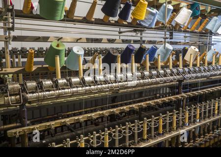 Bunte Spulen mit Garnen auf Drehrahmen in Baumwollmühle/Spinnerei | Machine de retordage dans filature cotonnière 11/02/2018 Stockfoto