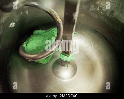 bäckerkoch, der rot-violett-gelb und grün kleine 30 Gramm farbige Brötchen für Fingerfood für Veranstaltungen macht - Catering-Zubereitung Stockfoto