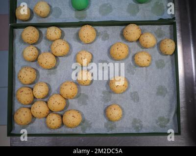 bäckerkoch, der rot-violett-gelb und grün kleine 30 Gramm farbige Brötchen für Fingerfood für Veranstaltungen macht - Catering-Zubereitung Stockfoto