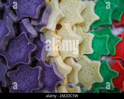 bäckermeister schneidet in der Gastronomieküche rote violettgelbe und grüne Sterne und herzförmige Buns Stockfoto