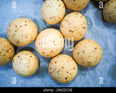 bäckerkoch, der rot-violett-gelb und grün kleine 30 Gramm farbige Brötchen für Fingerfood für Veranstaltungen macht - Catering-Zubereitung Stockfoto