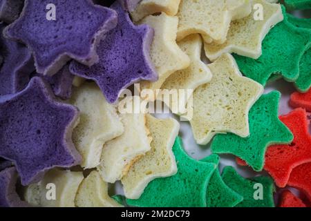 bäckermeister schneidet in der Gastronomieküche rote violettgelbe und grüne Sterne und herzförmige Buns Stockfoto