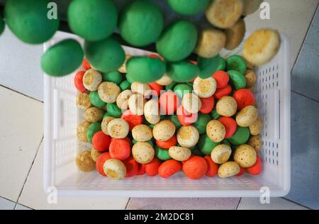 bäckerkoch, der rot-violett-gelb und grün kleine 30 Gramm farbige Brötchen für Fingerfood für Veranstaltungen macht - Catering-Zubereitung Stockfoto