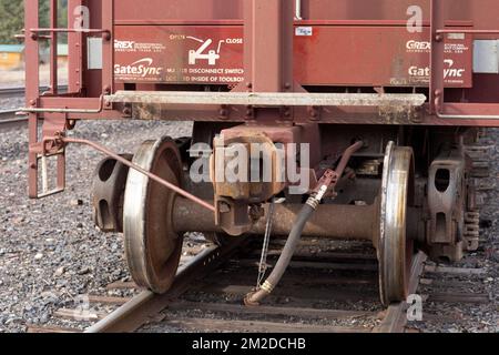 Troy, Montana, USA. 23. Februar 2021. Der Koppler, die Räder und der LKW auf einem nicht gekoppelten Eisenbahntrichter, auf den Gleisen, auf dem BNSF-Bahnhofplatz. Stockfoto