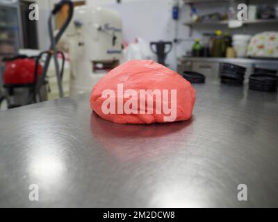 bäckerkoch, der rot-violett-gelb und grün kleine 30 Gramm farbige Brötchen für Fingerfood für Veranstaltungen macht - Catering-Zubereitung Stockfoto