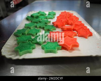 bäckermeister schneidet in der Gastronomieküche rote violettgelbe und grüne Sterne und herzförmige Buns Stockfoto