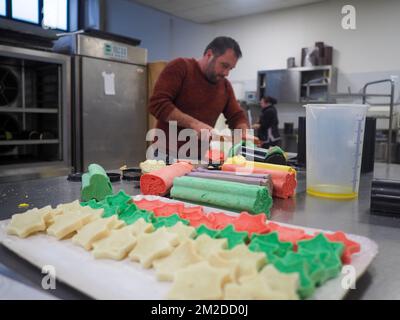 bäckermeister schneidet in der Gastronomieküche rote violettgelbe und grüne Sterne und herzförmige Buns Stockfoto