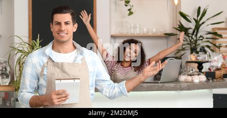 Portrait of young business owner and his happy worker in cafe Stock Photo