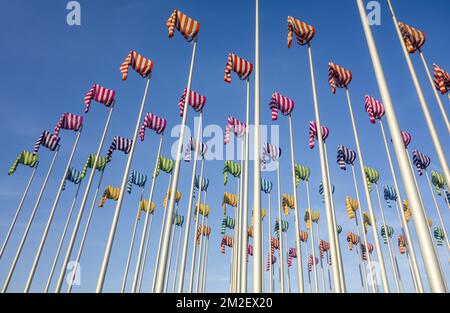 Kunstwerk Le Vent Souffle où il veut vom Künstler Daniel Buren, hundert Flaggenmasten mit bunten Windsocken in Nieuwpoort / Nieuport, Westflandern, Belgien | Oeuvre d'Art Le Vent Souffle où il veut par l'Artisten Daniel Buren à Nieuport, Belgique 18/04/2018 Stockfoto