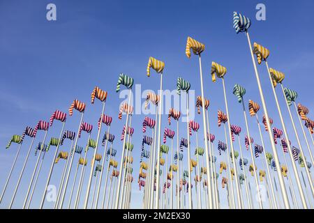 Kunstwerk Le Vent Souffle où il veut vom Künstler Daniel Buren, hundert Flaggenmasten mit bunten Windsocken in Nieuwpoort / Nieuport, Westflandern, Belgien | Oeuvre d'Art Le Vent Souffle où il veut par l'Artisten Daniel Buren à Nieuport, Belgique 18/04/2018 Stockfoto