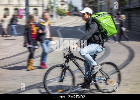 UberEATS / Uber Eats online meal ordering and delivery platform, bicycle courier delivering meals in the city center | Coursier à vélo de UberEATS / Uber Eats, service de livraison de plats cuisinés à Gand, Belgique 03/05/2018 Stock Photo