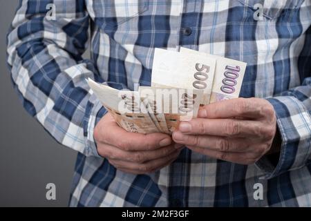 Zählung der tschechischen Krone in verschiedenen nominalen Banknoten CZK. Halten Sie ein kleines Bargeld bereit. Tschechische Finanzkonzept. Nahaufnahme mit selektivem Fokus. Stockfoto