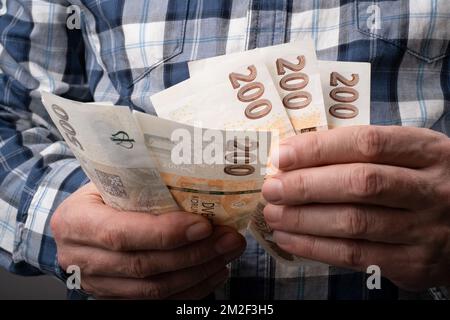 Zählung der tschechischen Krone in verschiedenen nominalen Banknoten CZK. Halten Sie ein kleines Bargeld bereit. Tschechische Finanzkonzept. Nahaufnahme mit selektivem Fokus. Stockfoto