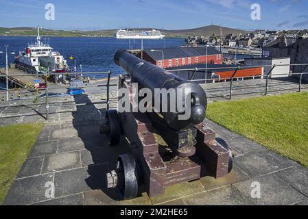 Kanone im Fort Charlotte des 17.. Jahrhunderts im Zentrum von Lerwick und Kreuzfahrtschiff im Bressay Sound, Shetland Islands, Schottland, Großbritannien | Canon dans le Fort Charlotte à Lerwick, Shetland, Ecosse 12/06/2018 Stockfoto