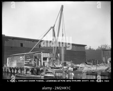Verteilerabteilung, Low Service Pipe Lines, Chelsea Creek Tunnel, Senking 42 Inch pipe into Chelsea Shaft, Chelsea, Mass., 18. Dez. 1914 Wasserwerke, Wassertunnel, Baustellen Stockfoto