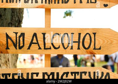 Unschärfe kein Alkohol-Zeichen ist auf einem Holzbrett. Kein Alkoholschild über einem überfüllten Straßenhaus. Symbol „Stopp zum Trinken“ – Symbol „Verboten“. Weigere dich, absteigend zu sein Stockfoto